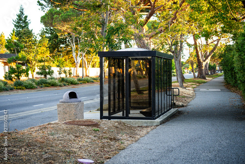 Obraz na płótnie Quiet bus stop surrounded by trees in a suburban area