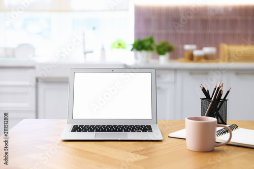 Comfortable workplace with laptop on wooden table indoors