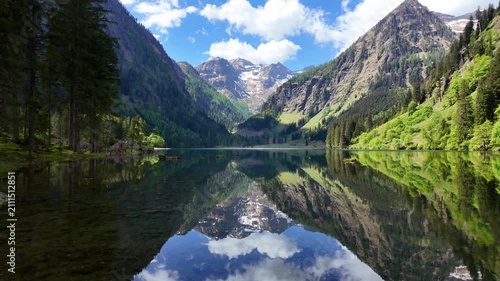 Scenic nature view over mountain lake. Reflective lake with mountain landscape. Landscape of mountain peak and valley lake. Nature landscape. Lake in wild nature forest scenery. Mountain reflection
