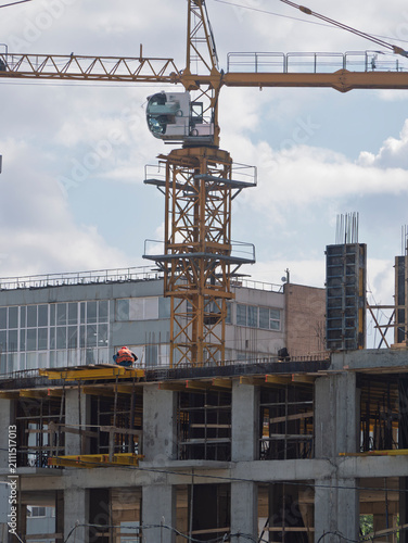 Industrial tower crane and worker at building construction site