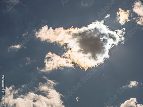 Canvastavla Sun shining through iridescent clouds in dark blue sky