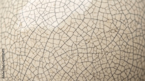 Abstract close-up texture of fine crack patterns on a ceramic surface