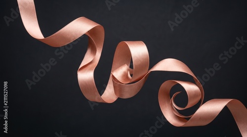 Elegant Rose Gold Silk Ribbon Flowing on a Minimalist Dark Black Background