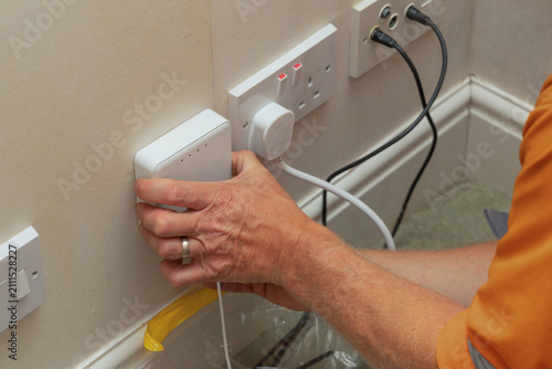 Bild auf Leinwand Telecoms engineer connecting SC APC fibre cable to optical network terminal on w