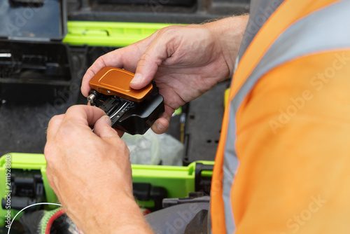 Canvas Print Telecoms engineer cleaving bare glass fibre with precision fibre cleaver before