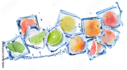 Obraz na plátne Fresh citrus fruits in ice cubes and water splash in air on white background