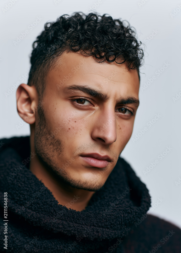 Obraz premium Young Curly Haired Man in Black Hoodie Portrait