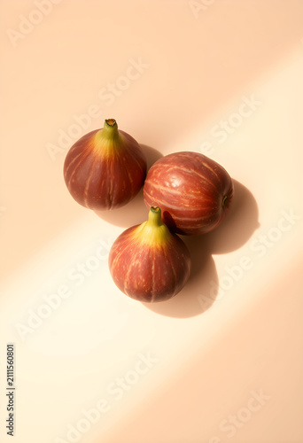 Three fresh figs on beige b...