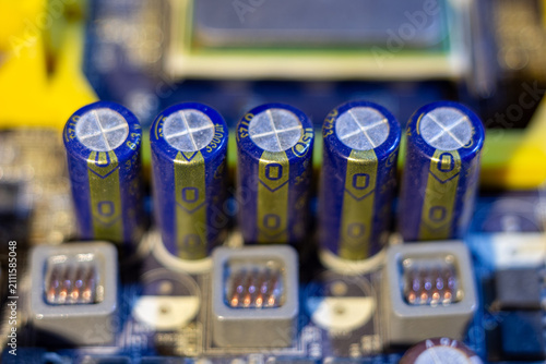 Fotografie Five blue electrolytic capacitors on a motherboard circuit board component