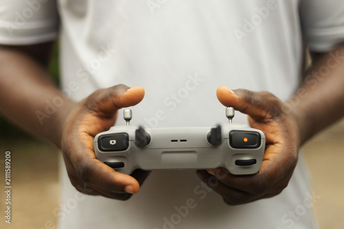 Hands operating the remote of a drone device
