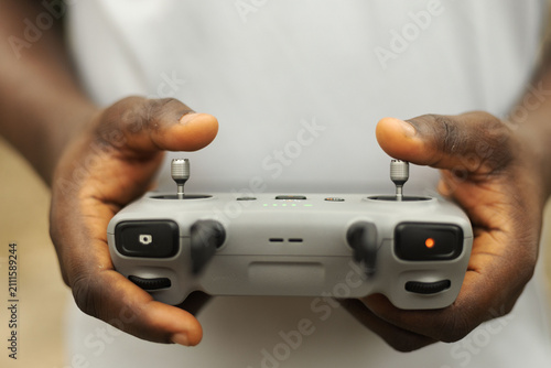 Hands operating the remote of a drone device
