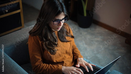 Foto Young Latina woman straining her eyes while using her laptop, representing digit