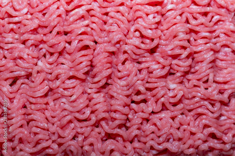 Fototapeta premium Fresh raw minced meat texture with wavy patterns of ground beef for cooking and food preparation