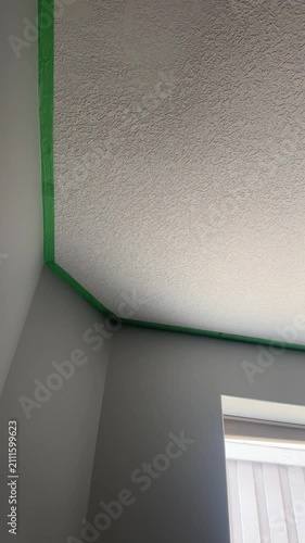 Close-Up Video of Painter’s Tape Applied Along Interior Wall and Ceiling During a Home Painting Project