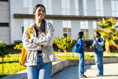 Smiling university student on campus with backpack outdoors