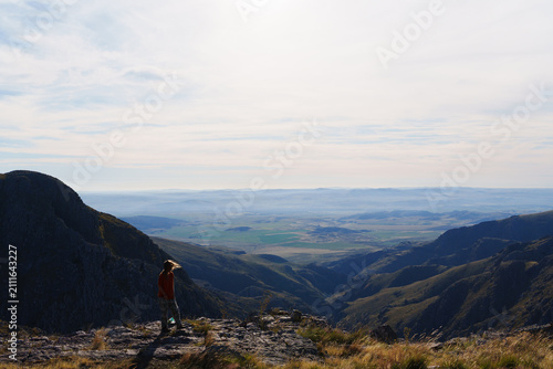Quadro su tela Woman with wind blown hair on a ridge overlooking a hazy morning dewy valley