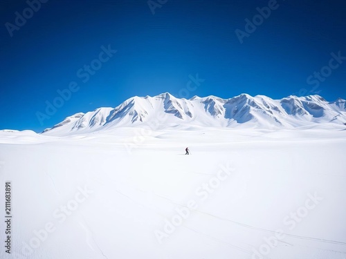 Snow-capped mountains tower over the ski field's vast expanse of white, winter, South Island