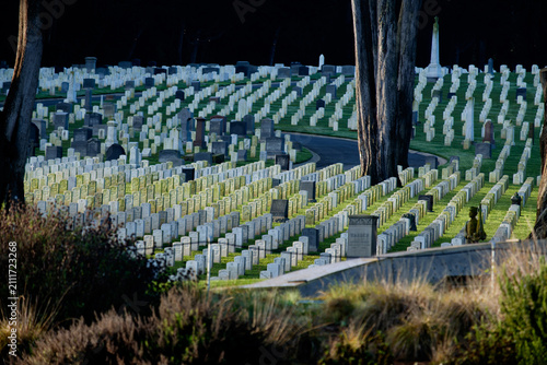 Rows of white headstones at San Francisco National Cemetery in golden evening light. g.