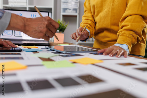 Fototapeta Ux designers engaging in a collaborative planning session. Reviewing app interface designs. Implementing mobile user experience principles. Tablet. And sticky notes