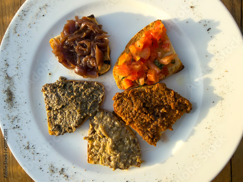 Traditional Tuscan Crostini Mixed Platter with Assorted Toppings on White Plate