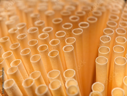 close-up pale yellow paper straws pattern.