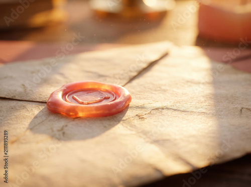 A small golden ring with a heart shape engraving on a rustic wooden table