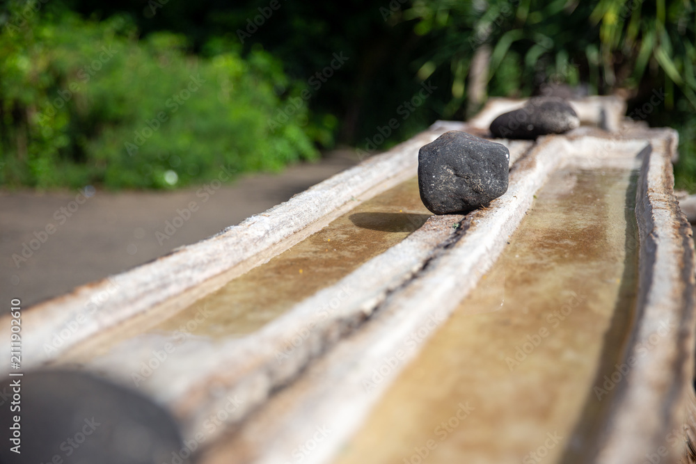 Fototapeta premium Traditional salt pan with black stones in Bali