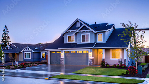 Bild auf Leinwand Modern suburban two story house exterior at dusk with illuminated and concrete d