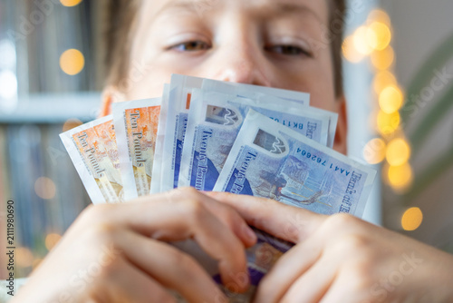 child 10 years old, primary school student presenting British GBP banknotes currency in hand, financial freedom, stealing money, adult imitation