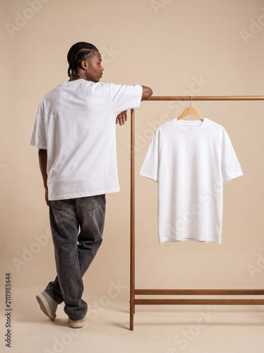 Man leaning on rack with white t-shirt mockup