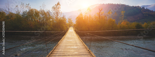 Hanging rope wooden bridge over mountain river