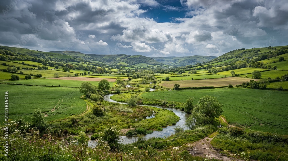Obraz premium Green farmland in a valley with a winding river. Scenic rural landscape with rolling hills.