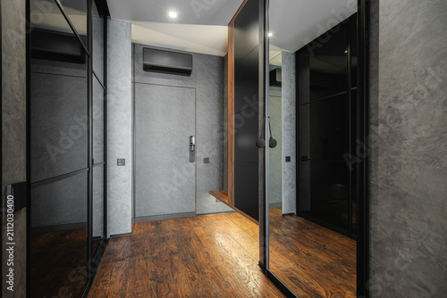 Fotografía Entrance hallway with black glass wardrobe and grey textures