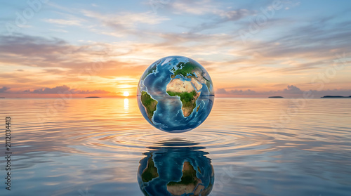 Glass planet earth sphere floating above tranquil ocean surface reflecting sunset light creating peaceful harmony scene.