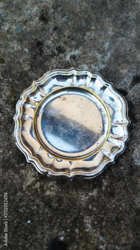 Vintage aesthetic silver plate on concrete background. Timeless aesthetic design template. Empty metal dish.