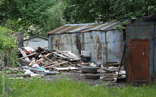 The remains of a broken metal shed among its peers
