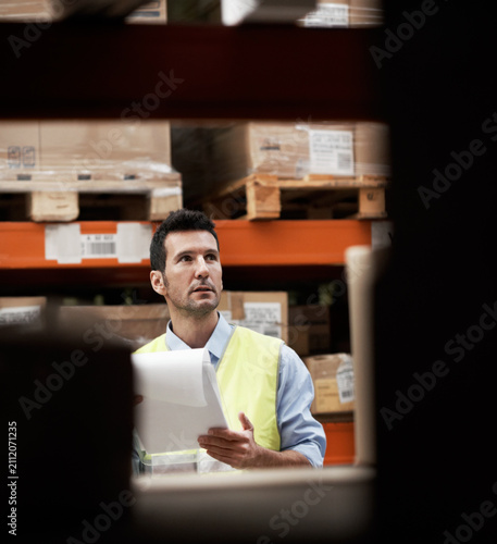 Clipboard  shipping and logistics with man in warehouse for inventory checklist  delivery schedule and cargo. Supply chain  quality control and distribution supervisor with person in factory