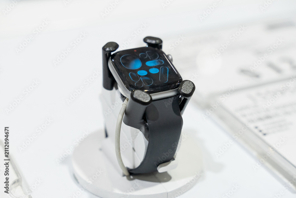 Naklejka premium Apple Watch models are displayed in a modern retail environment featuring various case finishes and watch bands. Close-up photographs emphasize the digital display, precision craftsmanship, health sen