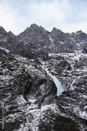 Принти на полотні Frozen cascade descending across a rugged alpine slope