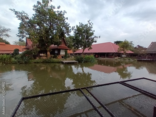A scenic view of partial floating market with wooden boats and shop houses.