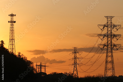 夕焼けの空と送電鉄塔と電波塔のシルエッ
