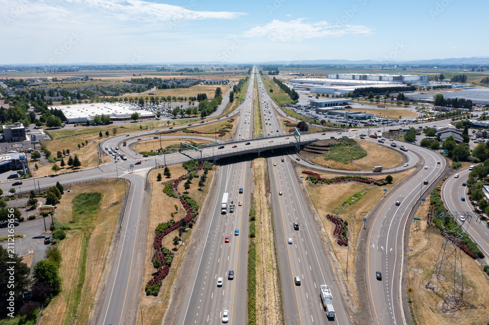Fototapeta premium Aerial drone photo of Interstate 5 (I-5) and highway interchange with connecting ramps near Woodburn, Oregon, USA showing regional transportation infrastructure and commuter traffic
