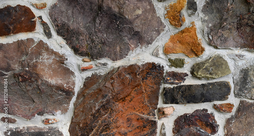 Bild auf Leinwand Close up of a multi color rock and mortar wall surface with porous, rough uneven
