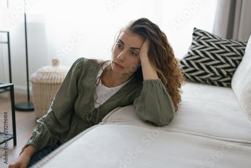 Obraz na płótnie Young adult woman with depression sitting at home alone