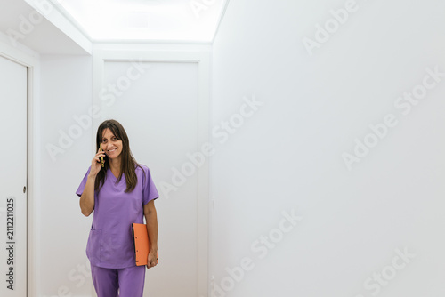 Optometrist walking and talking on the phone at her practice