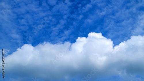 Foto massive white cloud stretching along bottom portion of blue sky