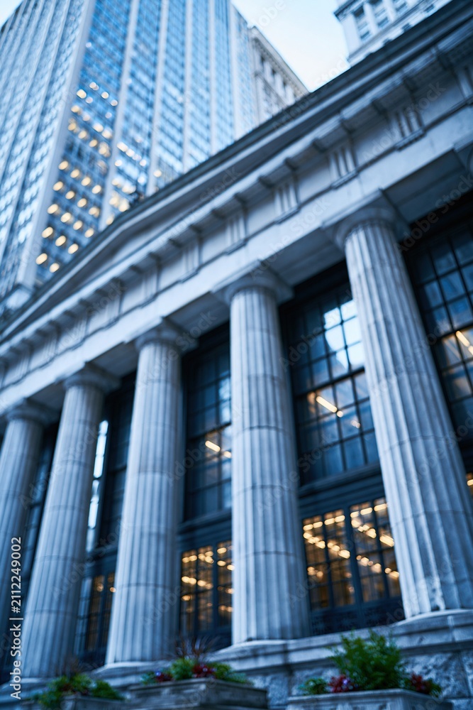 Obraz premium Majestic classical architecture with imposing columns and modern skyscraper in a city financial district