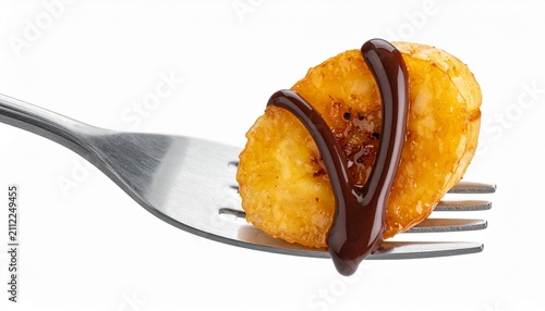 Delicious caramelized banana slice with chocolate sauce on a silver fork isolated on white background