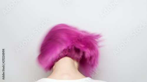 Dynamic movement of vibrant pink hair as a young woman shakes her head in studio, energetic flow and hairstyle care concept