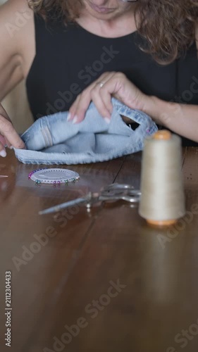 Hand sewing denim jeans hem with thimble scissors pins vertical- Rec709 Color Graded
